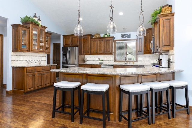 938 W Northstar Dr, Appleton, WI 54913 - kitchen featuring appliances with stainless steel finishes, tasteful backsplash, a peninsula, glass insert cabinets, and dark wood-type flooring