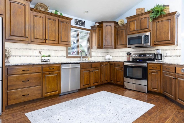 938 W Northstar Dr, Appleton, WI 54913 - kitchen featuring stainless steel appliances, lofted ceiling, a sink, tasteful backsplash, and light stone counters