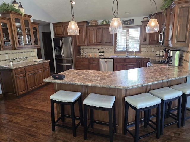938 W Northstar Dr, Appleton, WI 54913 - kitchen featuring appliances with stainless steel finishes, decorative backsplash, glass insert cabinets, a peninsula, and dark wood finished floors