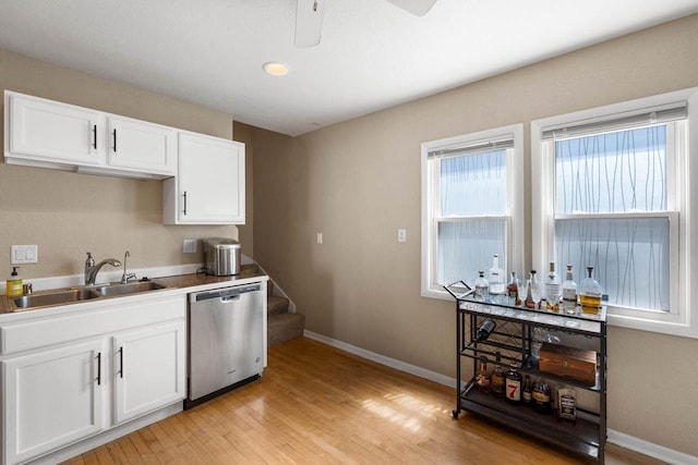 1568 S 63rd St, West Allis, WI 53214 - kitchen featuring stainless steel dishwasher, a sink, light wood finished floors, a ceiling fan, and baseboards