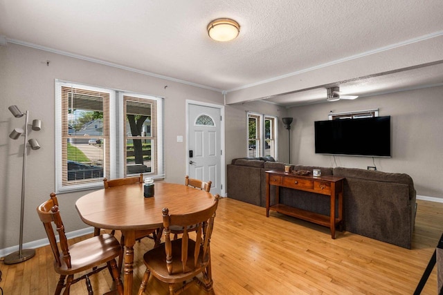 1568 S 63rd St, West Allis, WI 53214 - dining space featuring light wood-style flooring, a textured ceiling, crown molding, and baseboards