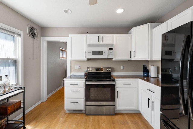 1568 S 63rd St, West Allis, WI 53214 - kitchen featuring white microwave, stainless steel electric stove, freestanding refrigerator, white cabinets, and recessed lighting
