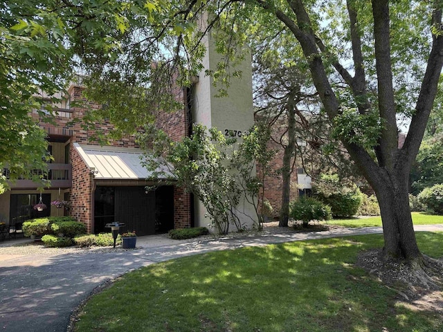 2470 W Good Hope Rd Unit 168, Glendale, WI 53209 - view of front facade with brick siding, a front lawn, a standing seam roof, and metal roof