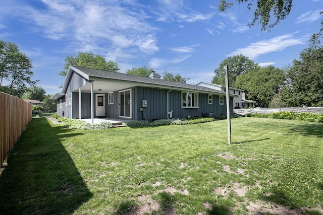 1016 E Marnie Ln, Appleton, WI 54911 - rear view of property with a patio, board and batten siding, and a chimney