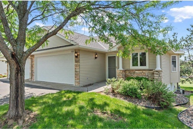 1102 Highpoint Ct, New Richmond, WI 54017 - view of front facade with stone siding, an attached garage, driveway, and a front lawn