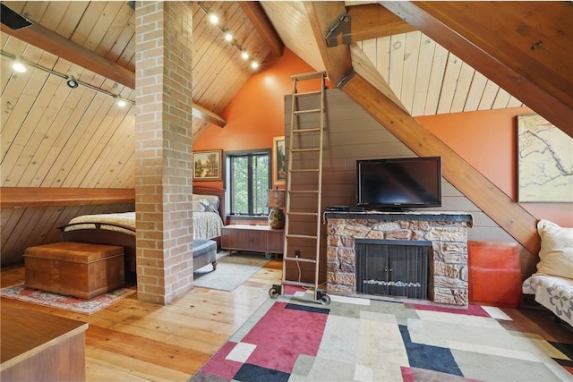 W11333 862nd St, River Falls, WI 54022 - living room featuring rail lighting, hardwood / wood-style floors, wooden ceiling, wood walls, and a stone fireplace