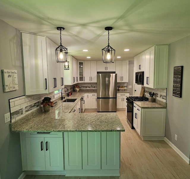 233 Inlet Shores Dr, Delavan, WI 53115 - kitchen with black appliances, a sink, tasteful backsplash, light stone counters, and a peninsula
