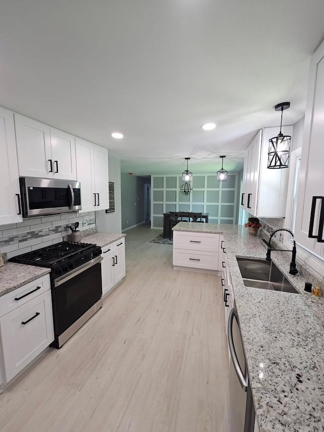 233 Inlet Shores Dr, Delavan, WI 53115 - kitchen featuring appliances with stainless steel finishes, a sink, tasteful backsplash, white cabinets, and recessed lighting