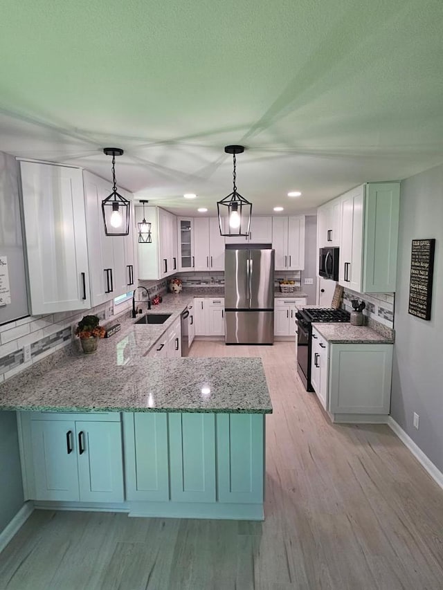 233 Inlet Shores Dr, Delavan, WI 53115 - kitchen featuring black appliances, a sink, backsplash, light stone counters, and a peninsula