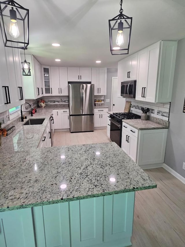 233 Inlet Shores Dr, Delavan, WI 53115 - kitchen featuring stainless steel appliances, a sink, light wood-style floors, light stone counters, and recessed lighting