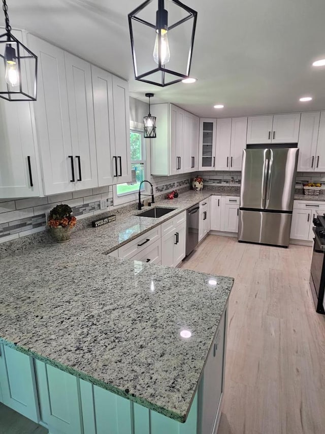 233 Inlet Shores Dr, Delavan, WI 53115 - kitchen featuring appliances with stainless steel finishes, a sink, backsplash, light stone counters, and white cabinets