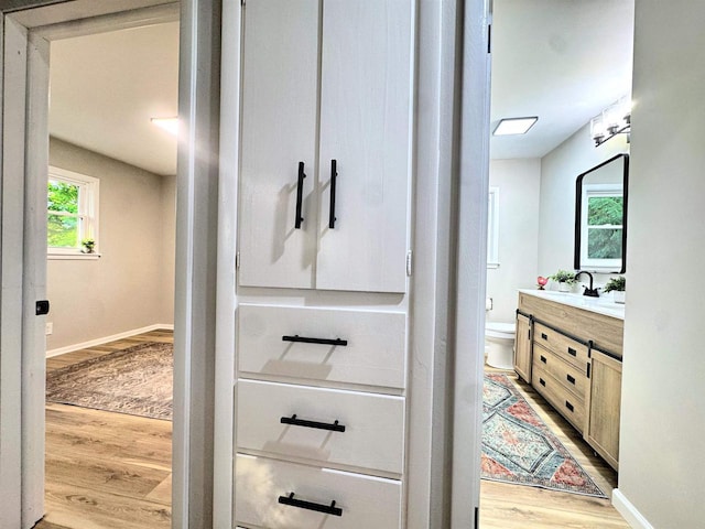 722 Michigan Ave, North Fond Du Lac, WI 54937 - bathroom featuring vanity, wood finished floors, toilet, and baseboards