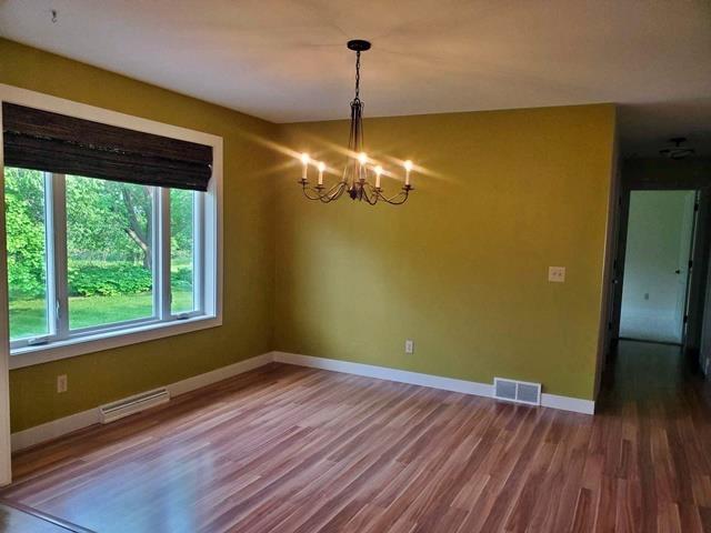 9350 County Road F, Milladore, WI 54454 - unfurnished room with a chandelier, baseboards, and wood finished floors