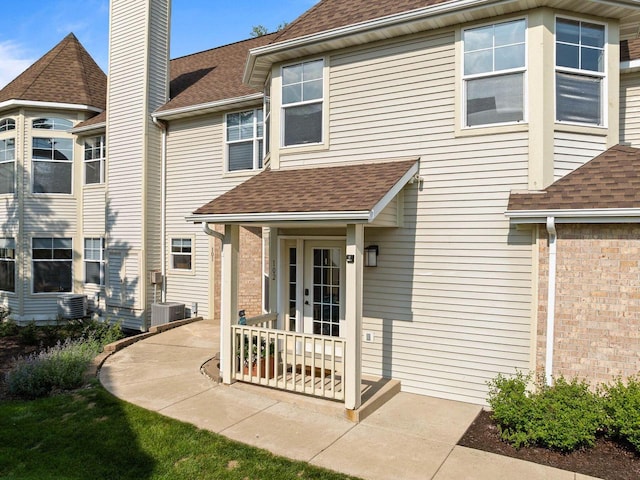 102 Abbey Ridge Ct Unit 102, Fontana, WI 53125 - rear view of house featuring a shingled roof, a chimney, and central AC