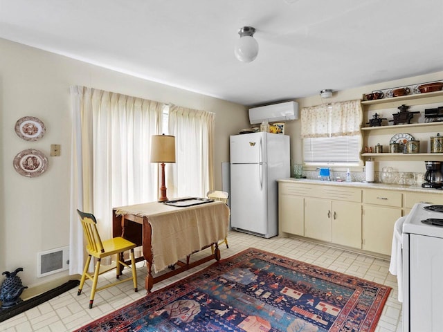 8090 State Highway 57, Baileys Harbor, WI 54202 - kitchen with white appliances, a wall mounted AC, healthy amount of natural light, and light countertops