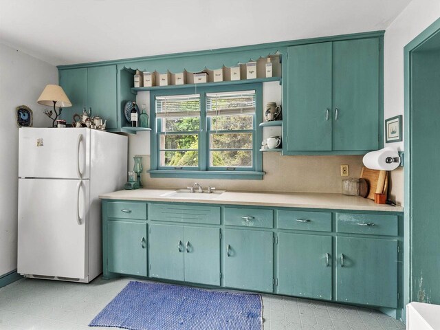 8090 State Highway 57, Baileys Harbor, WI 54202 - kitchen featuring freestanding refrigerator, open shelves, light countertops, and a sink
