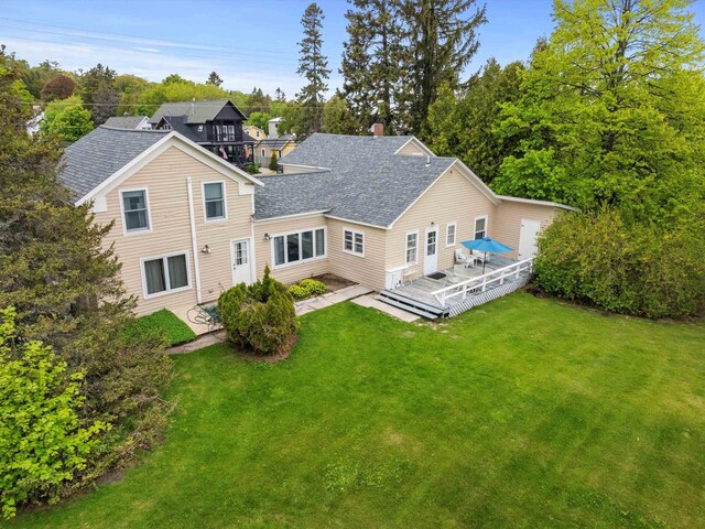 8090 State Highway 57, Baileys Harbor, WI 54202 - rear view of house with a wooden deck, a yard, roof with shingles, a patio area, and a chimney