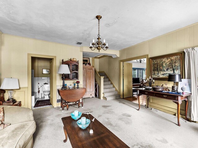 8090 State Highway 57, Baileys Harbor, WI 54202 - carpeted living room with stairway, a chandelier, and a decorative wall