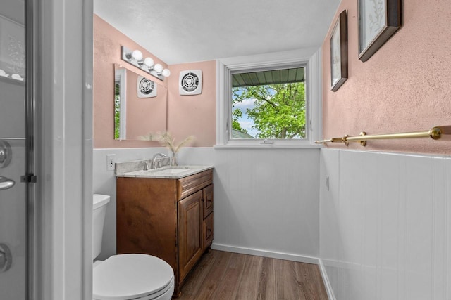 4080 Windermere Ln, Oshkosh, WI 54902 - bathroom featuring wood finished floors, vanity, toilet, and a wainscoted wall