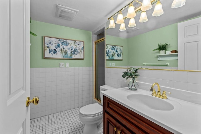 4080 Windermere Ln, Oshkosh, WI 54902 - bathroom with tile walls, toilet, vanity, an enclosed shower, and tile patterned floors