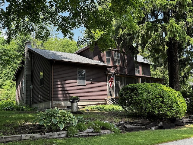432 W Capitol Dr, Hartland, WI 53029 - view of home's exterior with a chimney, a sunroom, and roof with shingles