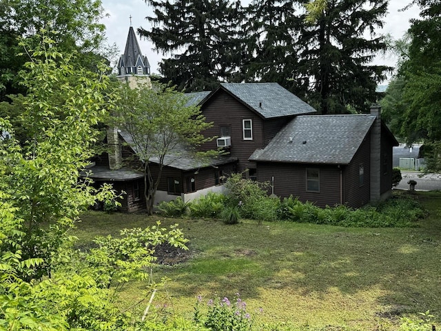 432 W Capitol Dr, Hartland, WI 53029 - back of property featuring roof with shingles, a chimney, and a lawn