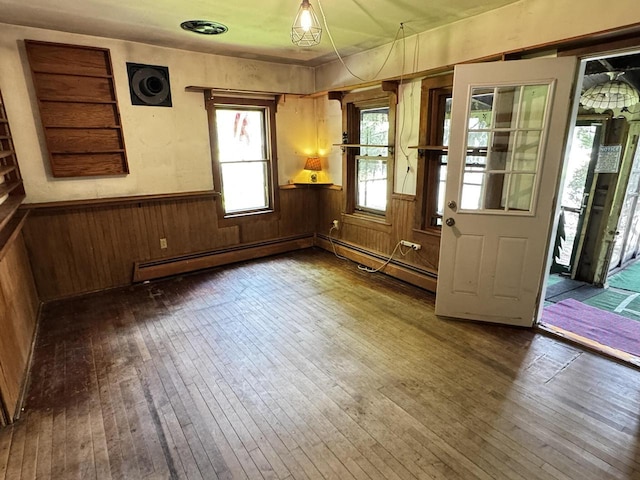 432 W Capitol Dr, Hartland, WI 53029 - unfurnished room featuring a baseboard heating unit, hardwood / wood-style flooring, a wainscoted wall, and wooden walls