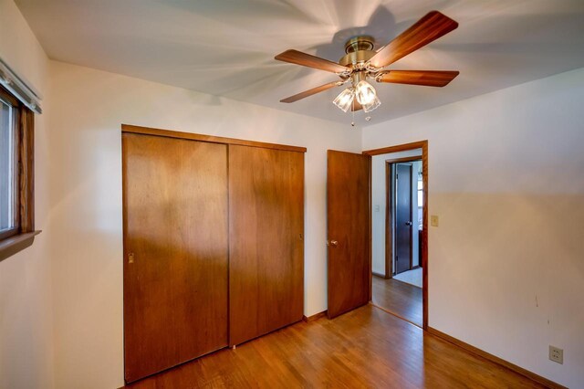 1516 Pierce Ave, Oshkosh, WI 54902 - unfurnished bedroom with a closet, wood finished floors, a ceiling fan, and baseboards