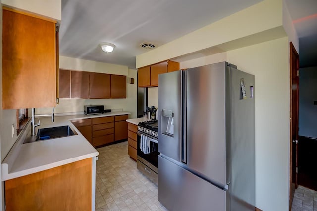 1516 Pierce Ave, Oshkosh, WI 54902 - kitchen with stainless steel appliances, brown cabinets, a sink, light countertops, and light floors