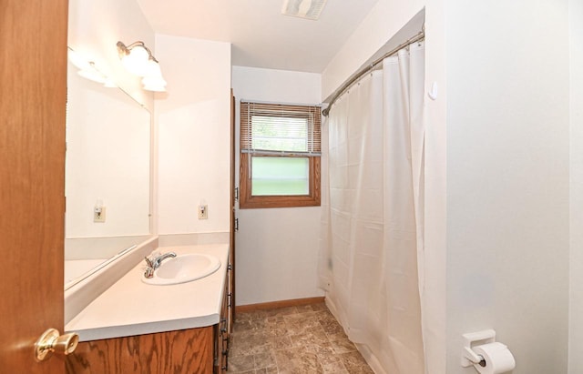 2016 Madera St Unit 2018, Waukesha, WI 53189 - bathroom with vanity, stone finish floors, a shower with shower curtain, and baseboards
