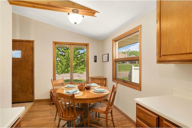 1711 Olive St, Stillwater, MN 55082 - dining room with lofted ceiling, light wood-style flooring, and baseboards