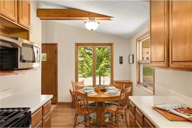 1711 Olive St, Stillwater, MN 55082 - dining room featuring vaulted ceiling, light wood-type flooring, and baseboards