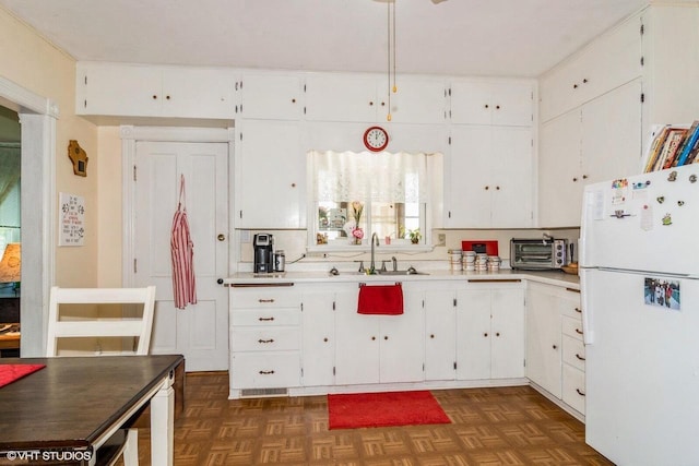 314 E Maple Ave, Beaver Dam, WI 53916 - kitchen featuring freestanding refrigerator, a sink, white cabinets, and light countertops
