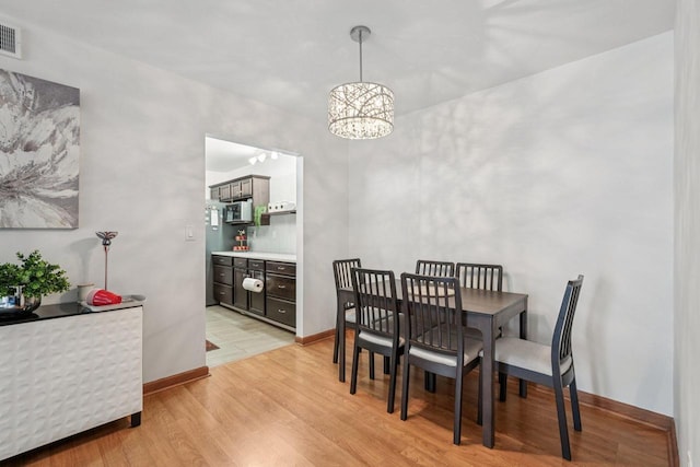2350 Good Hope Rd Unit 156, Glendale, WI 53209 - dining area featuring a chandelier, light wood finished floors, and baseboards