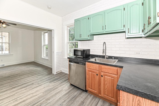1443 Summit Ave, Racine, WI 53404 - kitchen featuring dishwasher, black microwave, dark countertops, decorative backsplash, and light wood-style floors