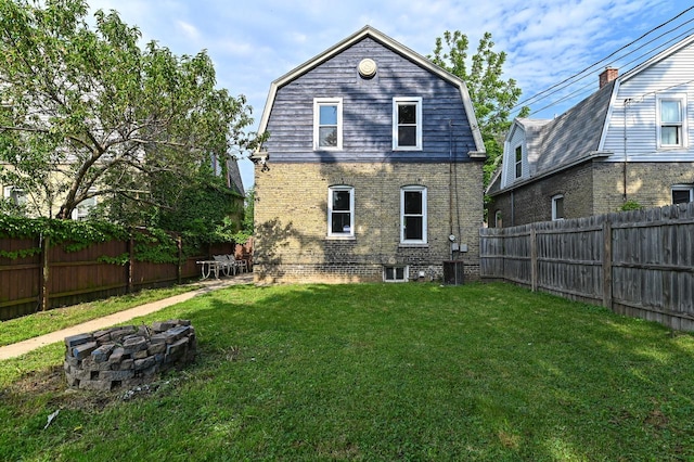 1443 Summit Ave, Racine, WI 53404 - back of house with a fire pit, a gambrel roof, a fenced backyard, and brick siding