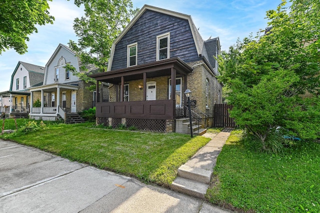 1443 Summit Ave, Racine, WI 53404 - dutch colonial featuring a gambrel roof, a porch, brick siding, and a front lawn