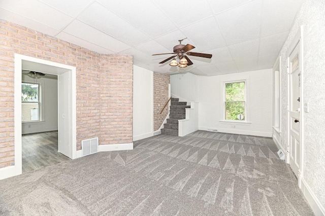 1443 Summit Ave, Racine, WI 53404 - unfurnished living room featuring a paneled ceiling, a ceiling fan, stairway, and carpet flooring