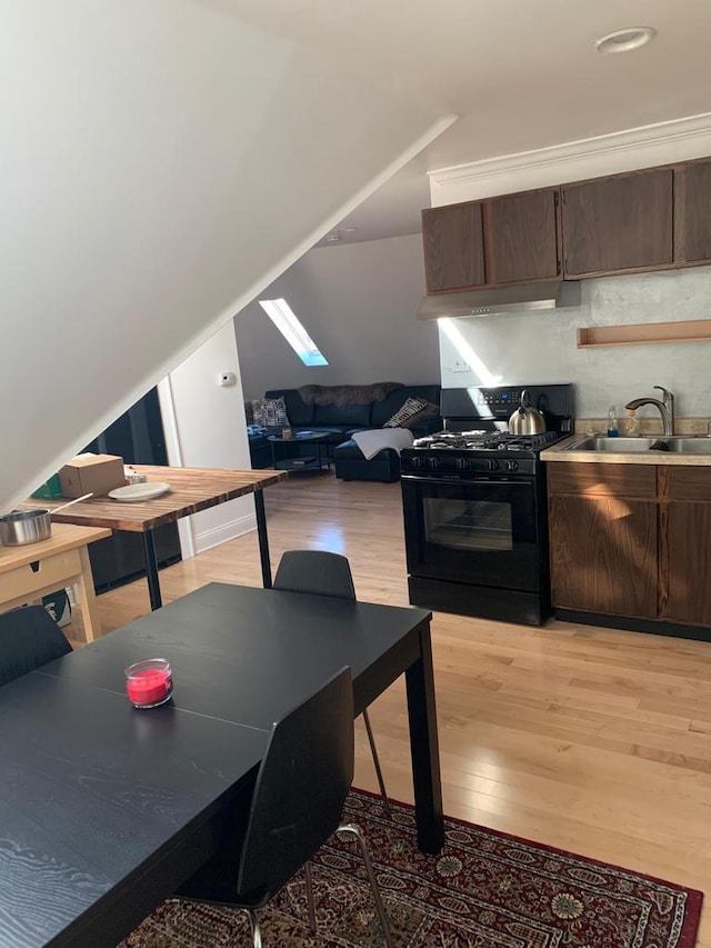 2723 N Downer Ave Unit 2725, 2725A, Milwaukee, WI 53211 - kitchen with black gas stove, light wood finished floors, a sink, and dark brown cabinetry