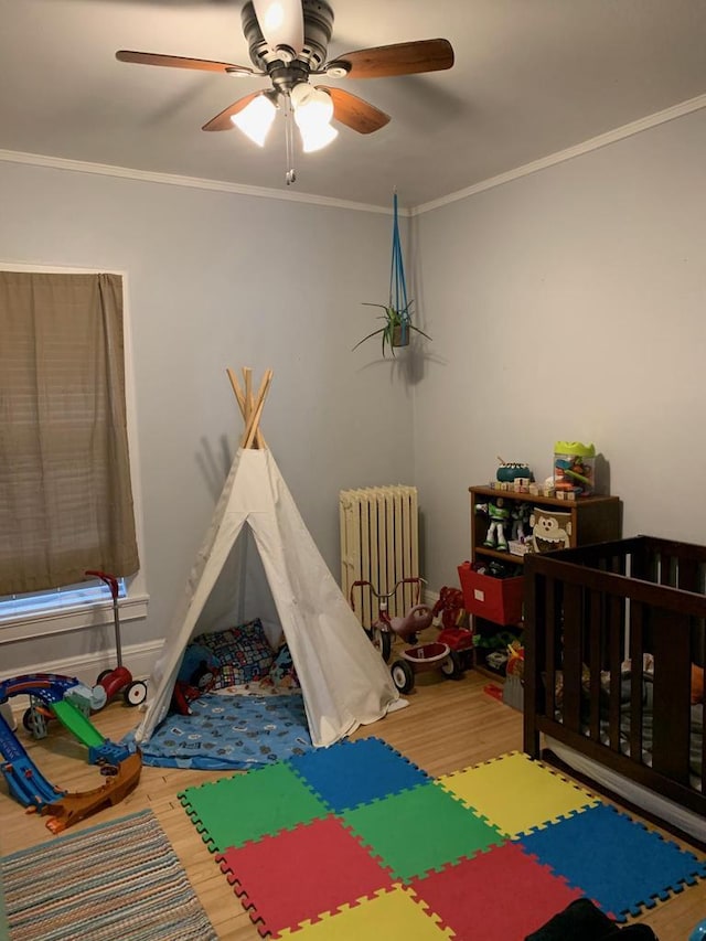 2723 N Downer Ave Unit 2725, 2725A, Milwaukee, WI 53211 - rec room with radiator heating unit, wood finished floors, a ceiling fan, and crown molding