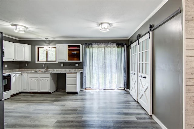 N211 County Road J, Hatfield, WI 54754 - kitchen with a sink, crown molding, white cabinetry, a barn door, and wood finished floors