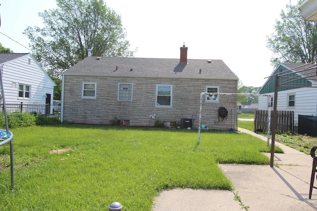 3253 S 68th St, Milwaukee, WI 53219 - back of property with stone siding, a chimney, and a trampoline
