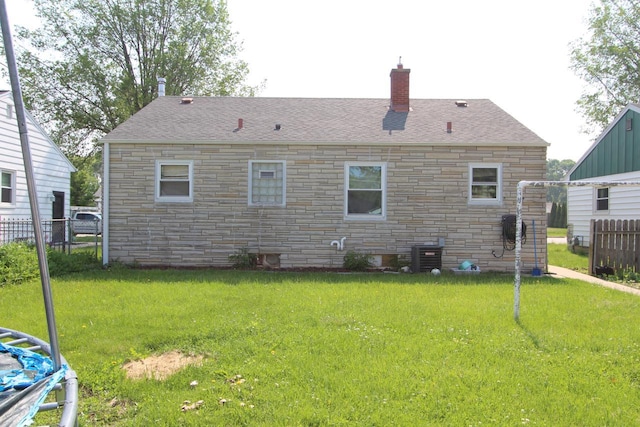 3253 S 68th St, Milwaukee, WI 53219 - back of property with stone siding, a chimney, roof with shingles, and central air condition unit