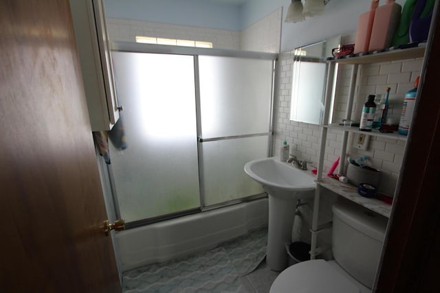 3253 S 68th St, Milwaukee, WI 53219 - bathroom featuring shower / bath combination with glass door, toilet, tile patterned flooring, tile walls, and a sink