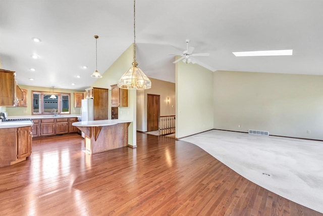 5073 Scottie Ct, New Franken, WI 54229 - kitchen with freestanding refrigerator, vaulted ceiling, light countertops, a sink, and open floor plan