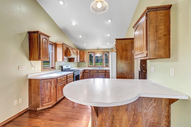 5073 Scottie Ct, New Franken, WI 54229 - kitchen with gas range, a peninsula, a sink, vaulted ceiling, and light countertops