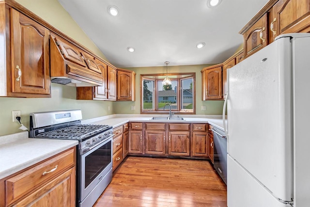 5073 Scottie Ct, New Franken, WI 54229 - kitchen featuring appliances with stainless steel finishes, a sink, brown cabinetry, light wood-style floors, and light countertops