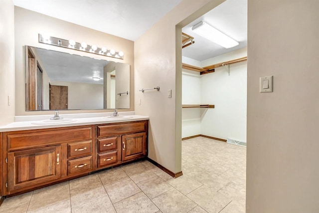 5073 Scottie Ct, New Franken, WI 54229 - bathroom with double vanity, a spacious closet, tile patterned flooring, and baseboards