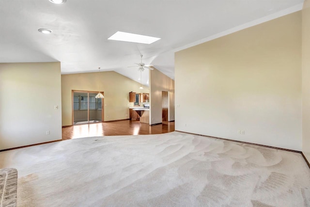 5073 Scottie Ct, New Franken, WI 54229 - unfurnished living room featuring baseboards, a skylight, lofted ceiling, carpet, and a ceiling fan