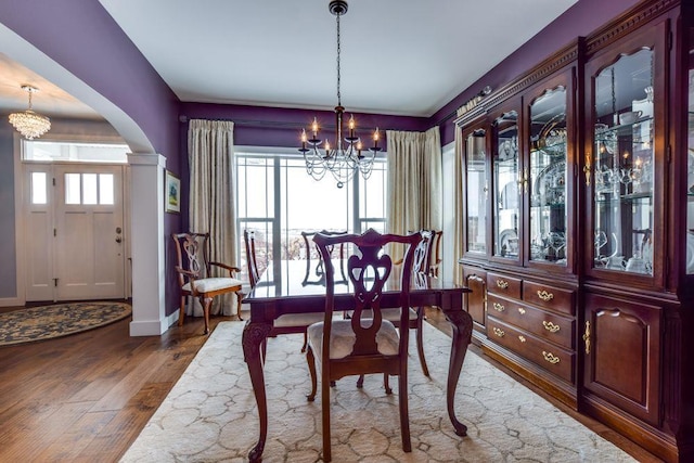 6663 S Chickahauk Trl, Middleton, WI 53562 - dining room featuring a chandelier, arched walkways, wood finished floors, and baseboards